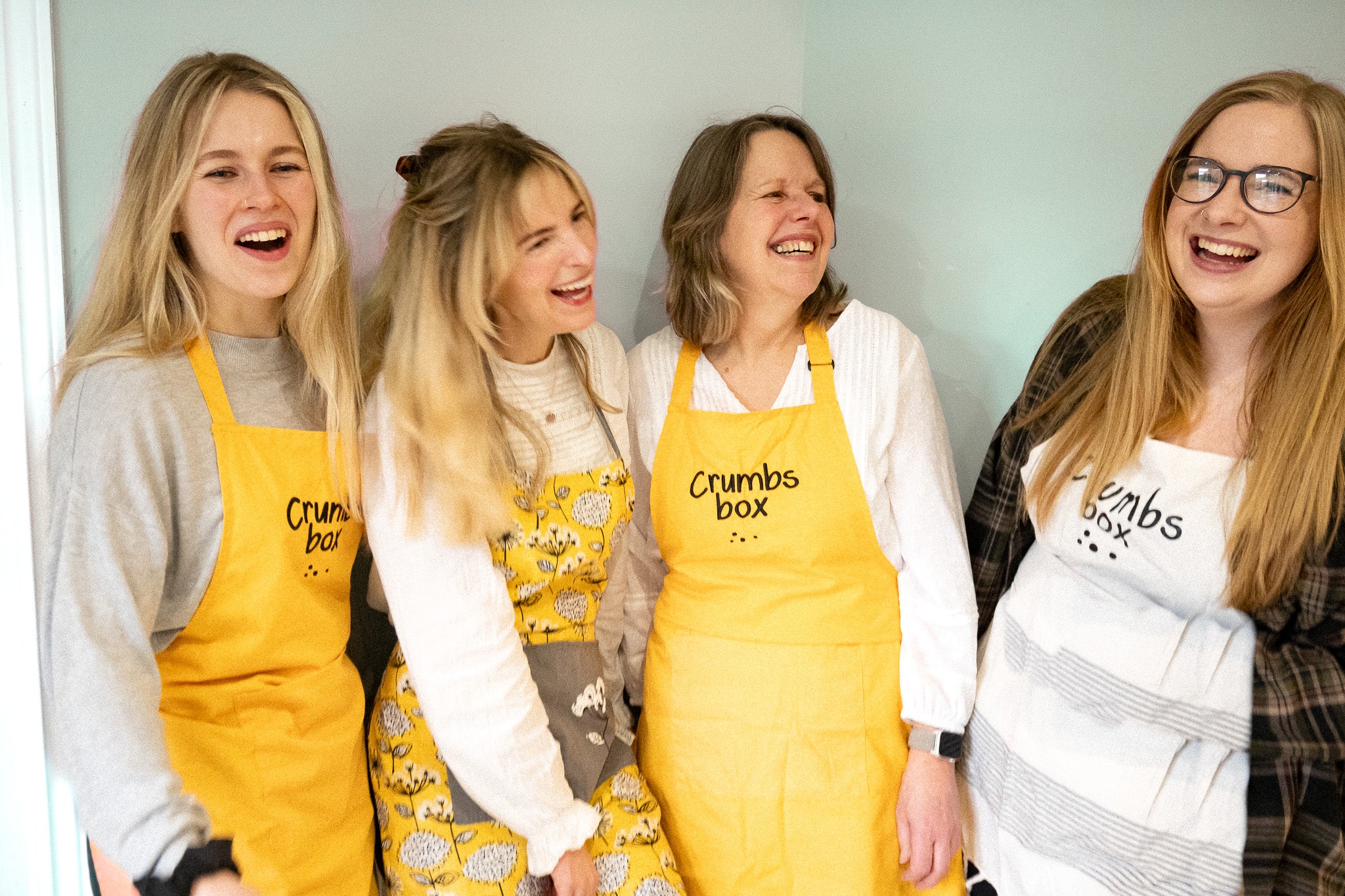 sisters and mum in crumbs box aprons