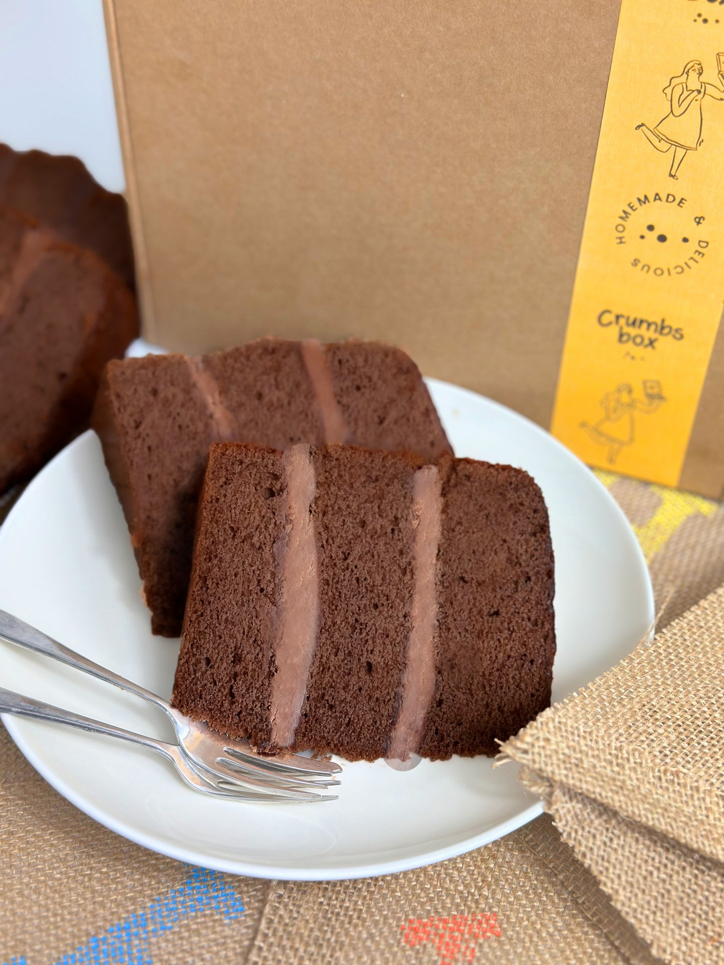 gluten free and dairy free chocolate cake slices on a plate with a crumbs box subscription